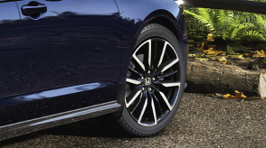 Closeup of wheel on a blue Accord outdoors. 