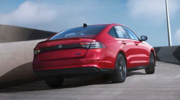 3/4 rear view of a red Accord ascending a ramp under a clear blue sky.