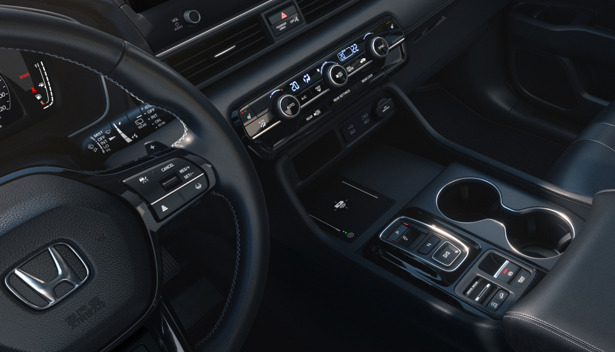 Driver’s side view of the steering wheel, dashboard, centre console and cup holders.
