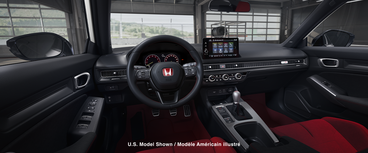 Panoramic view of steering wheel and front dashboard. Out the windshield, we see an open racing garage door.